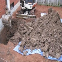 Image of an excavator digging the foundation to perform an exterior foundation crack repair