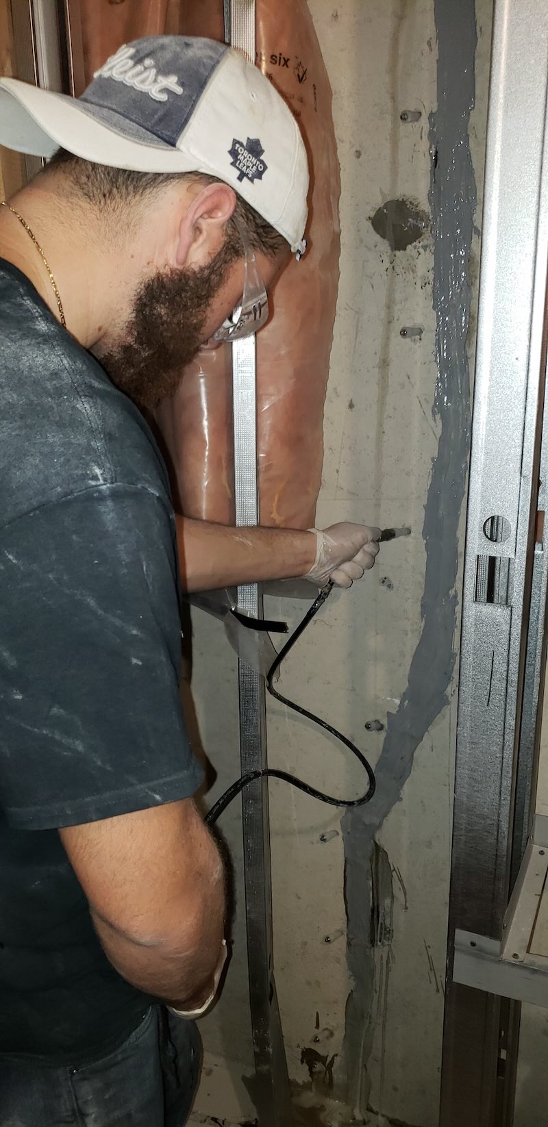 Technician performing polyurethane foundation crack injection inside an Oakville basement.