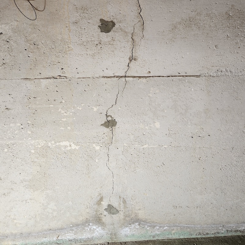 Foundation wall crack caused by concrete shrinkage and minor settlement
