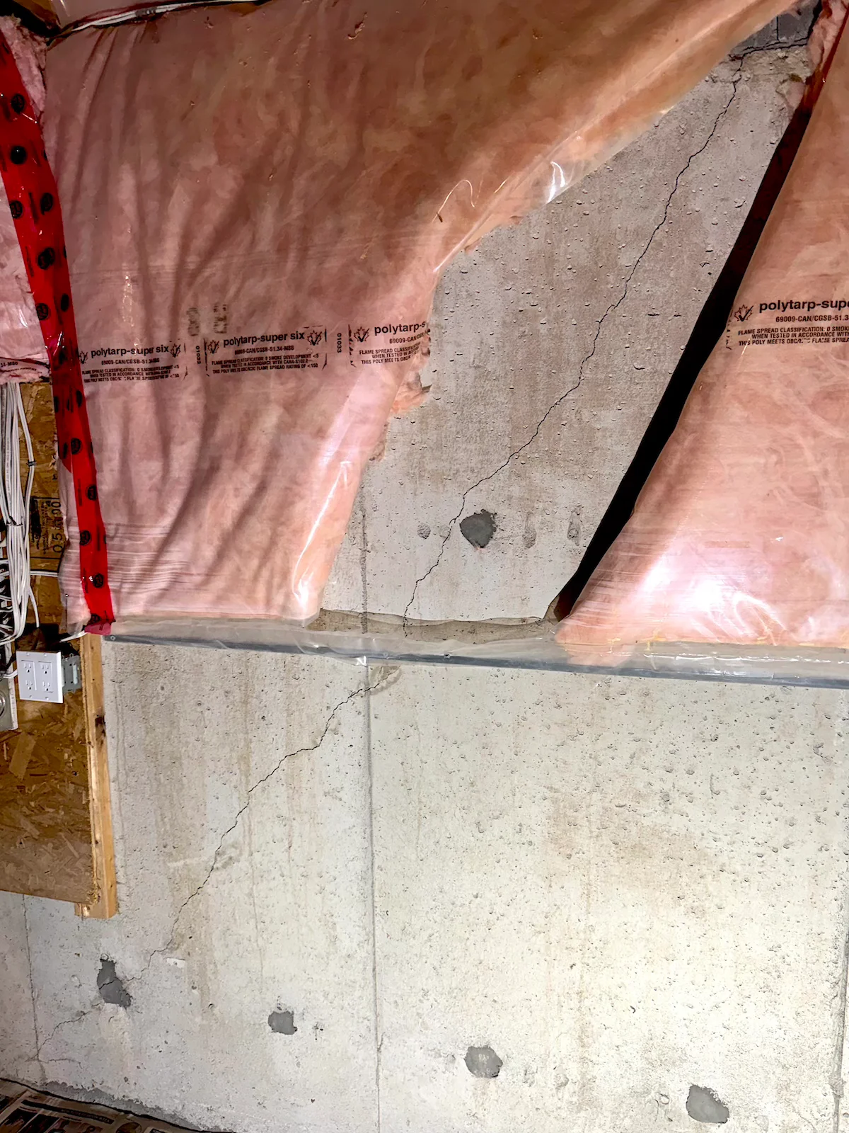 Diagonal settlement crack in a poured concrete foundation wall.