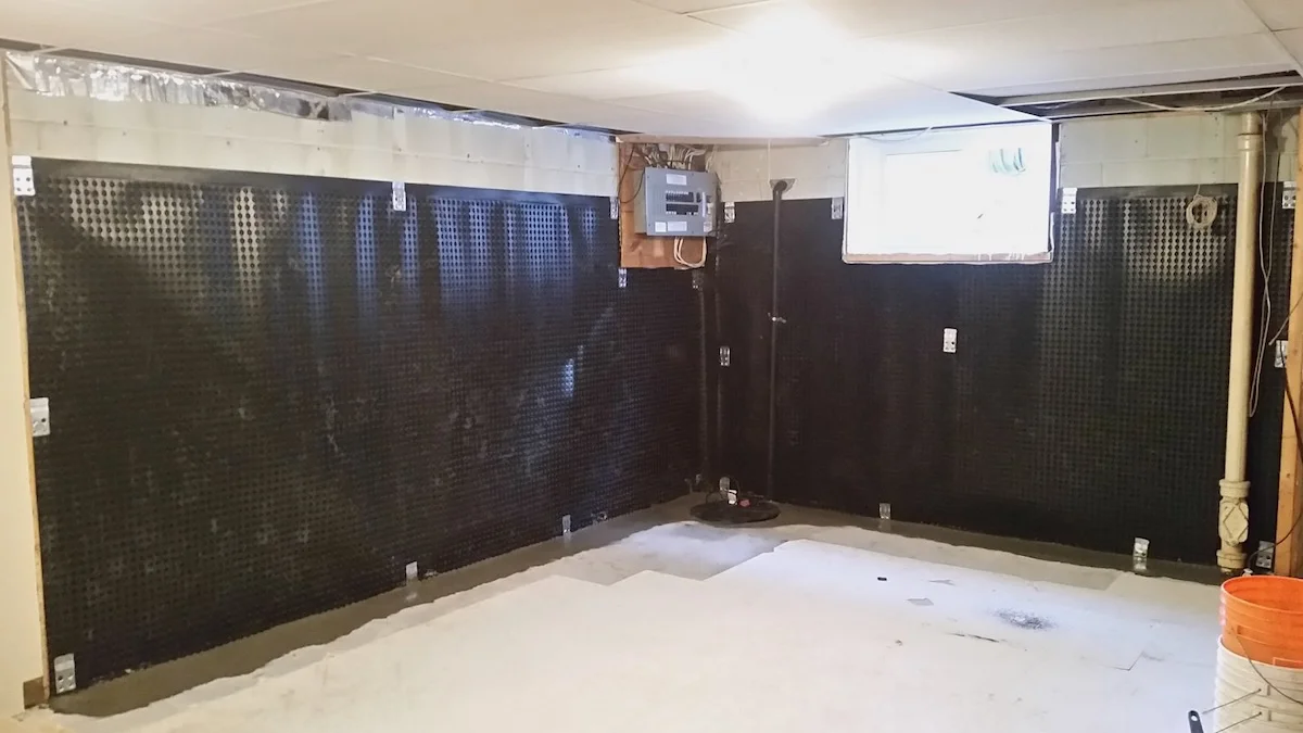 Interior basement waterproofing system with drainage membrane and weeping tile designed to relieve hydrostatic pressure beneath the basement floor.