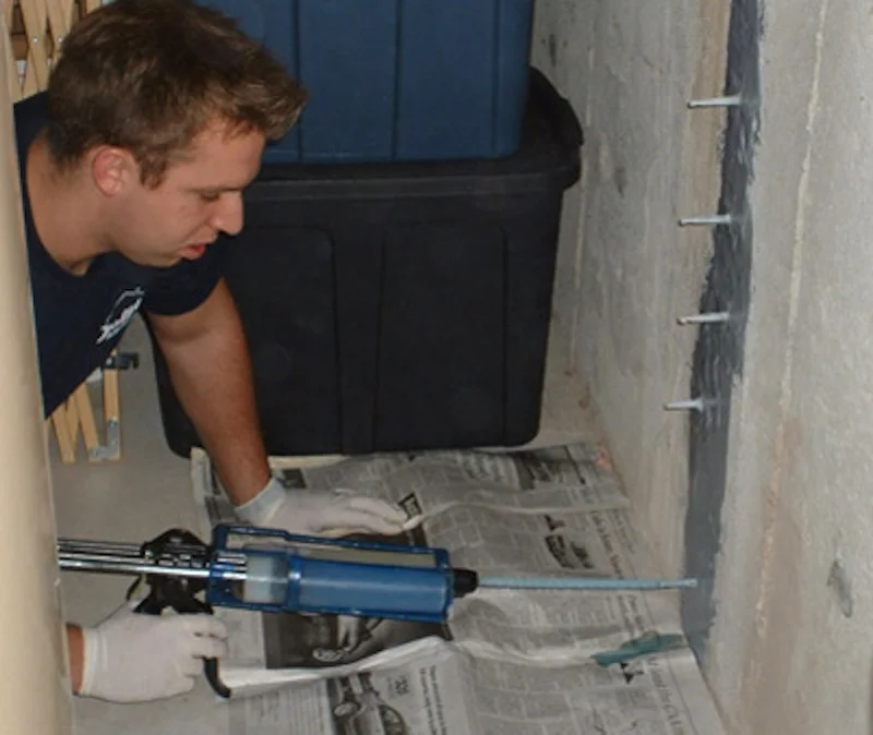 Low-pressure foundation crack injection using surface-mounted T-ports and a dispensing gun.