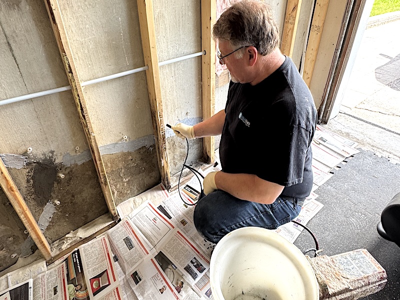 High-pressure polyurethane injection being performed to repair a leaking foundation crack