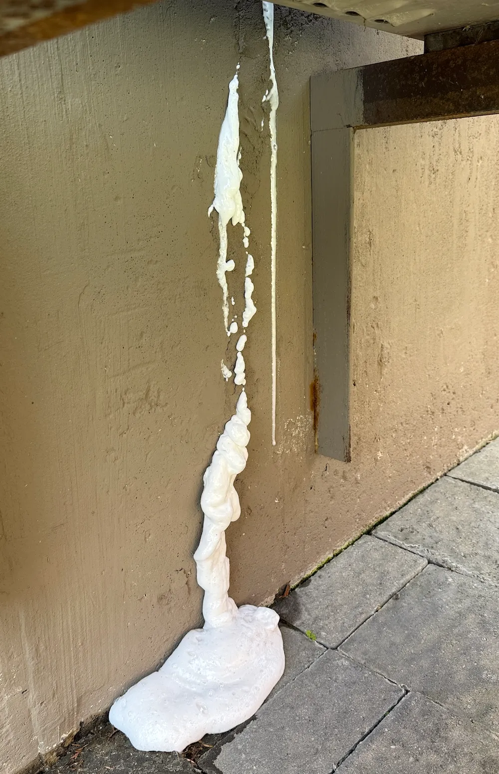 Polyurethane visible on the exterior side of a foundation wall after a crack injection repair.