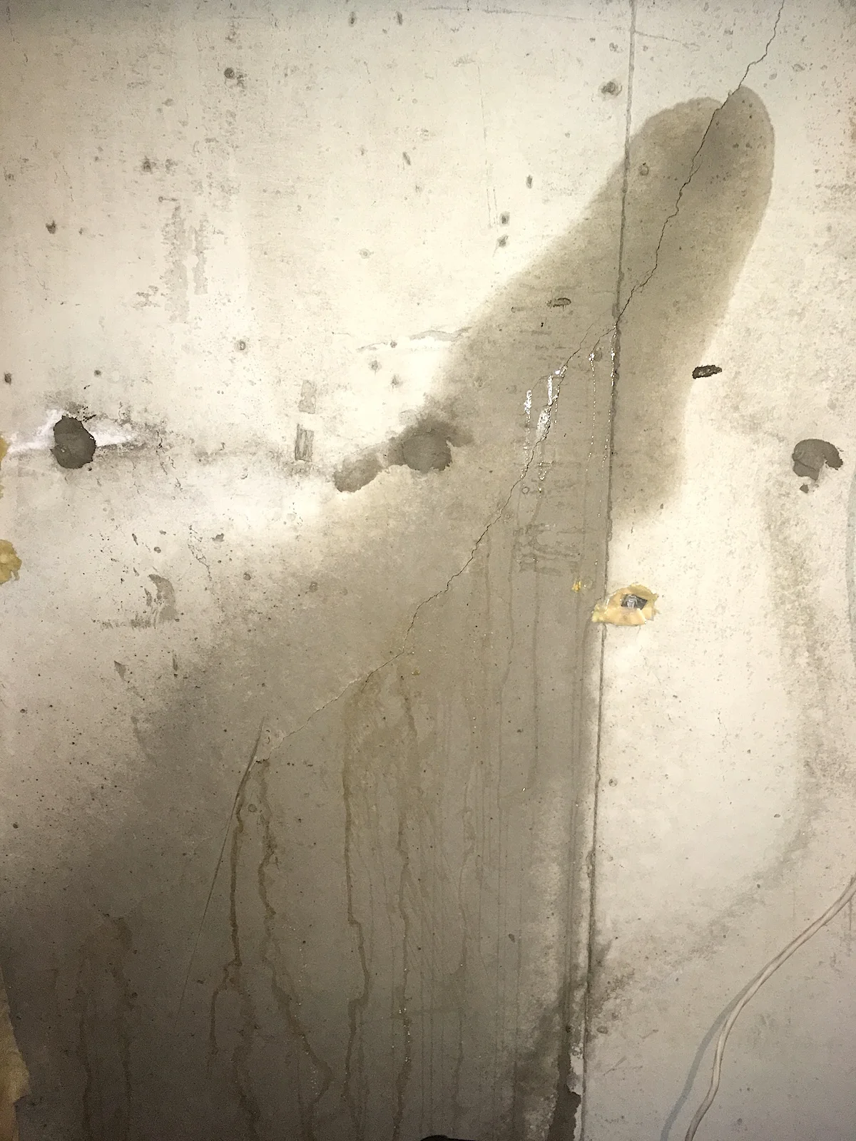 Dark moisture staining on a poured concrete foundation wall